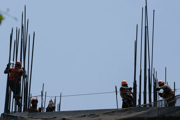Construction workers setting up the metal support rods to a building, an image to illustrate foreign investment in Mexico