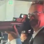 Former U.K. ambassador to Mexico Jonathan Benjamin points an assault rifle at the camera in a blurry video screenshot